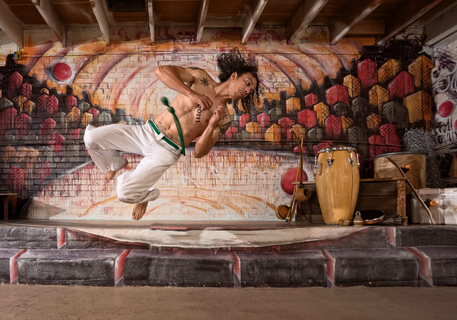 Handsome mixed capoeira performer flipping mid air