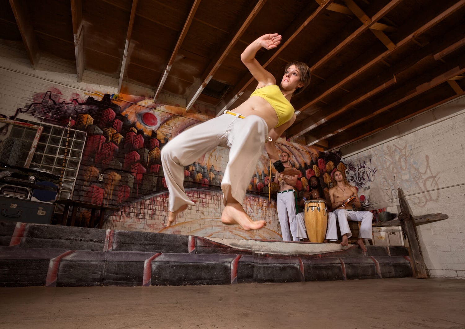 Flexible woman performing a capoeira jumping kick